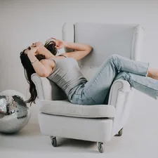 woman sitting on sofa chair related to Dreaming of a Comfortable Rest: Bobs Furniture Beds