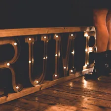 woman standing in front of brown rumble marquee sign on floor related to Define a Rustic Atmosphere