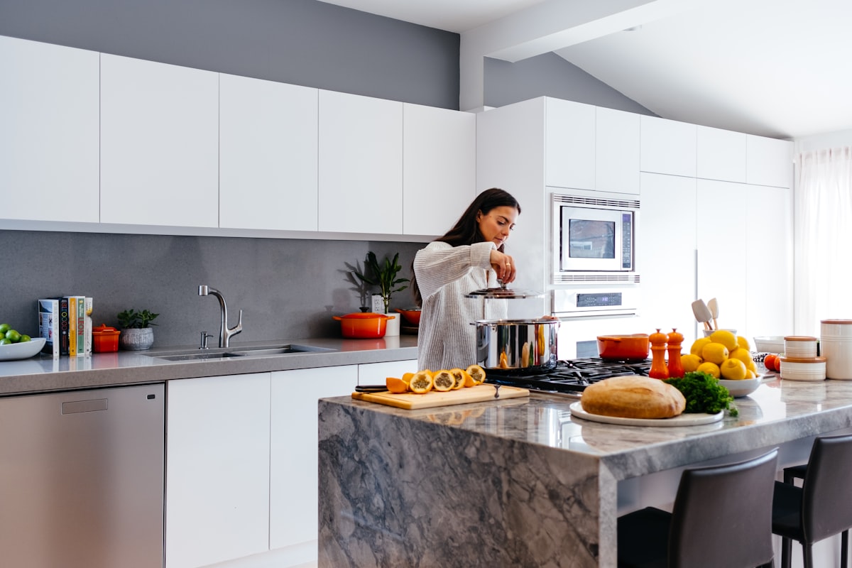 woman standing in front of table related to Elevate Your Kitchen Style with Blue Kitchen Valances