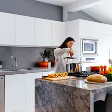 woman standing in front of table related to Elevate Your Kitchen Style with Blue Kitchen Valances