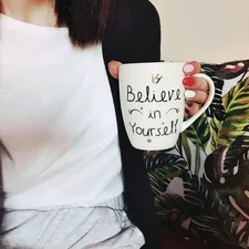 woman wearing black cardigan holding mug related to Unleash Your Inner Style: Three Original Takes on Scarf Valance Hooks