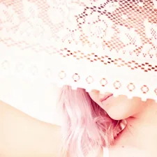 Woman with pink hair under white lace related to Enchanting Slumber: The Magic of Bed Canopies for Girls