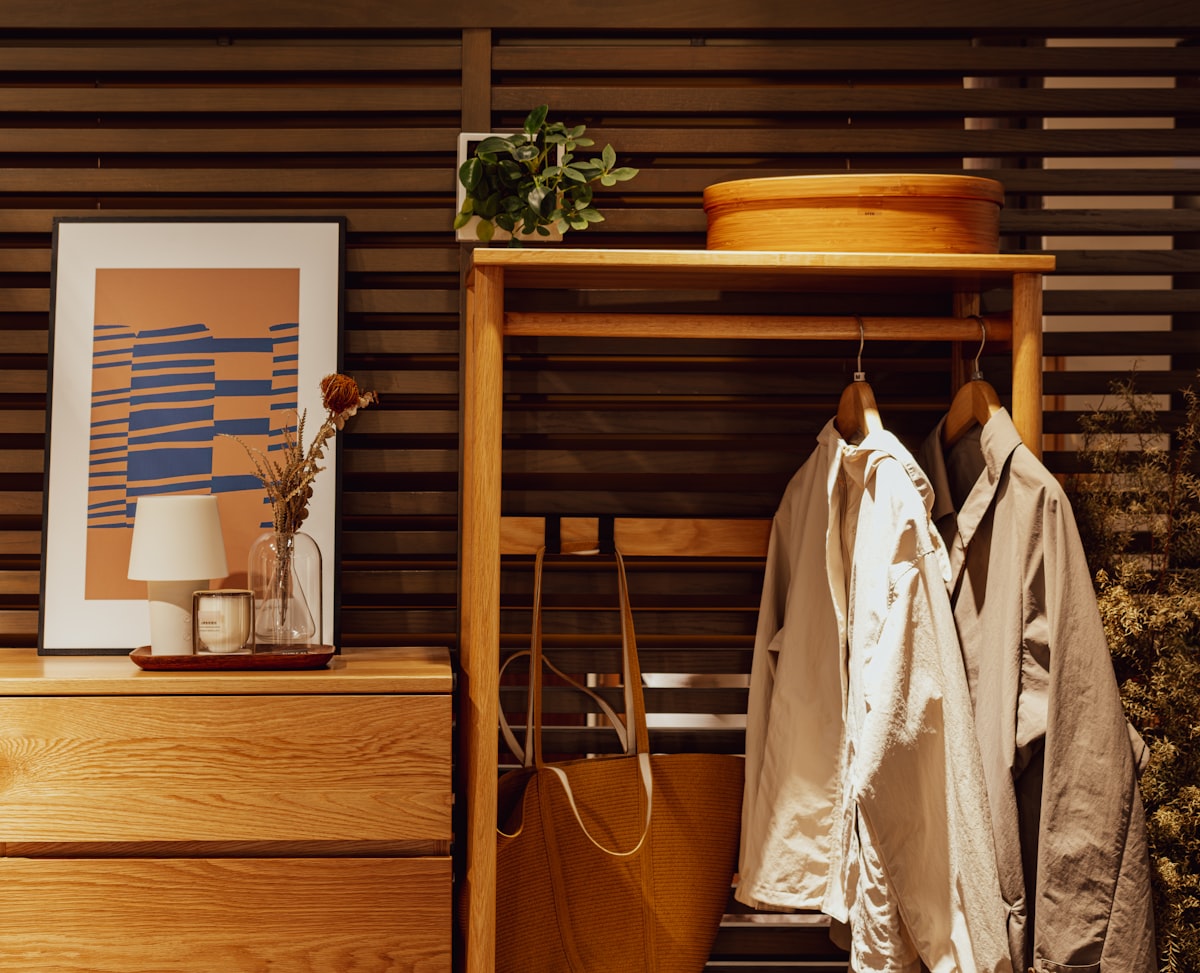 Wooden dresser with artwork and hanging coats related to Elevate Your Entryway: Stylish Small Entryway Tables to Welcome You Home