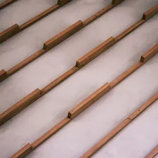 Wooden slats arranged diagonally on a light grey surface. related to The Ultimate Guide to Bed Slats Full