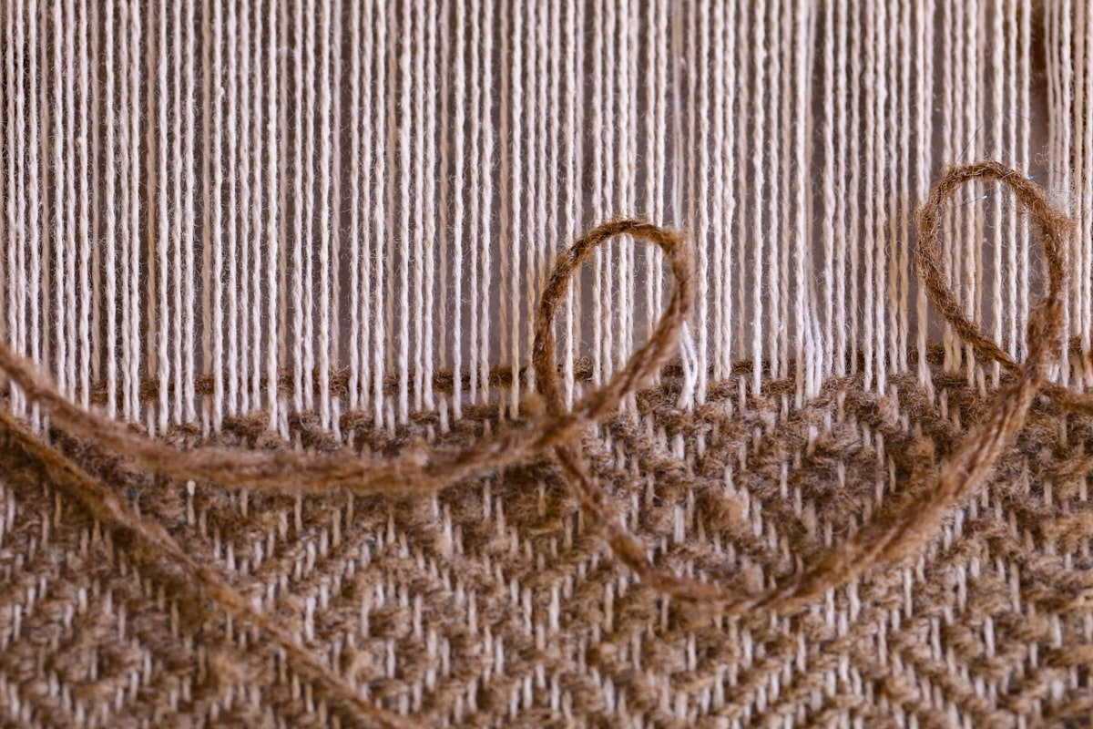 Wool string loom at a pioneer village showing 1800's era techniques for making fabric and rugs. related to Reproduction Woven Coverlets