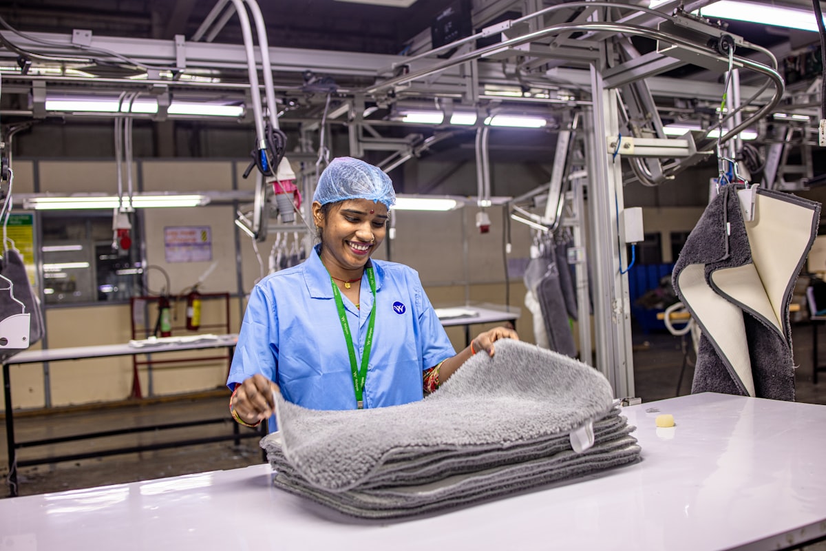 Worker inspecting folded textiles in a factory. related to Discover Empowering Opportunities at Bed Bath & Beyond