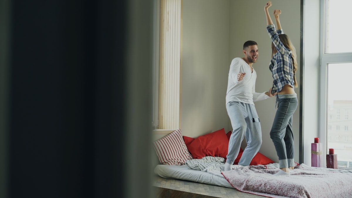 Young beautiful and loving couple dancing rocknroll dance on bed in morning at home related to Effective Exercises You Can Do Right in Bed