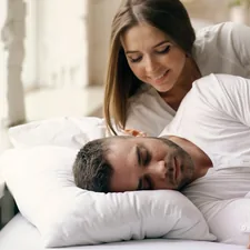 Young beautiful and loving couple wake up at morning. Attractive woman kiss and hug his husband in bed related to Unwrapping the Bliss of Bed and Body Works