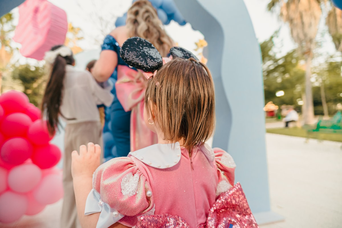 Young child in pink dress at a party related to Magical Slumber: A Guide to Disney Princess Toddler Beds