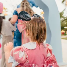 Young child in pink dress at a party related to Magical Slumber: A Guide to Disney Princess Toddler Beds