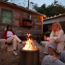 Young friends relaxing in the backyard around a firepit at night, on Trippy Chairs related to Cozy Up Your Backyard with Chimineas at Lowe's