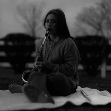 Young woman playing saxophone outdoors at dusk related to Transform Your Bedroom with Musical Themes